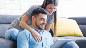 A couple enjoying watching something on their laptop