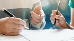Two patients filling out forms