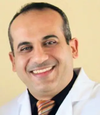 Portrait Of Handsome Male Dentist Posing In Dental Clinic.